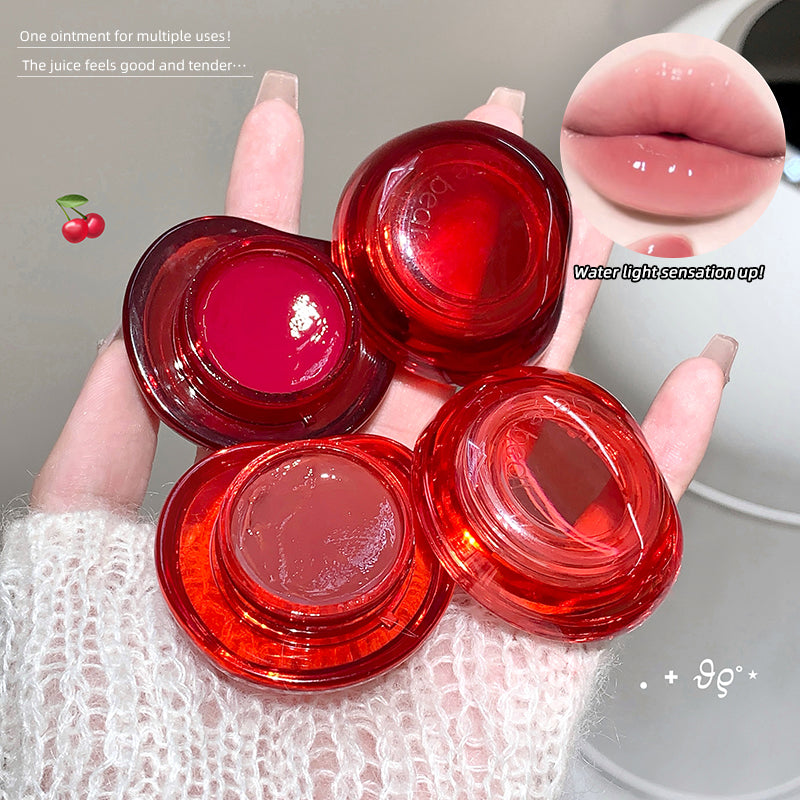 Red lip balm containers held by a hand with a blurred background