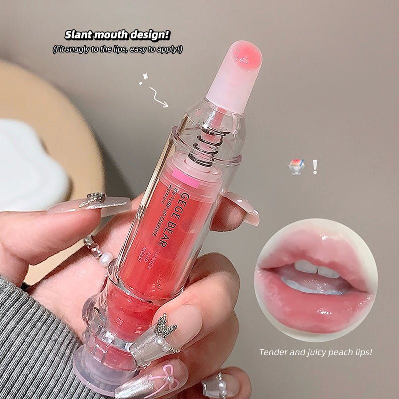 Lip gloss with slant mouth design held by a hand, showing close-up of lips.
