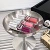 Three pink lipsticks on a metallic stand with a blurred background