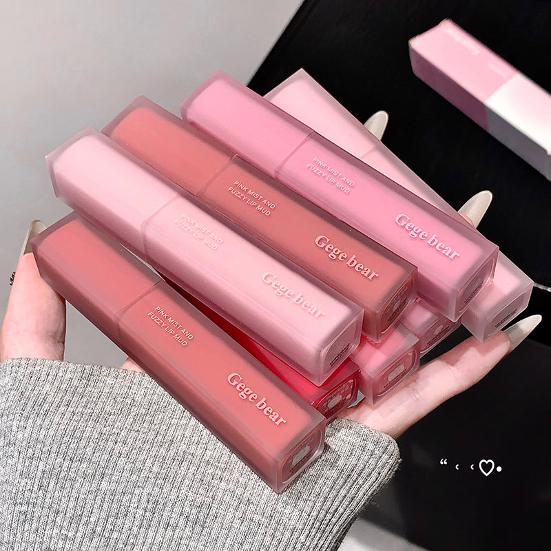 Pink lip gloss tubes with 'Gege bear' branding held in a hand against a neutral background.
