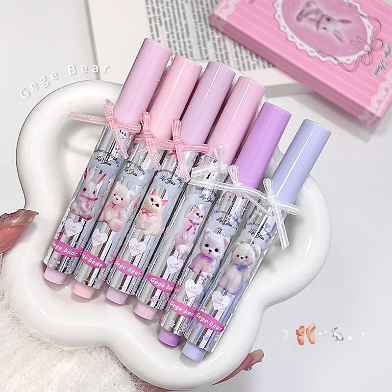 Set of pink and purple lip balms with bear designs on a white heart-shaped tray.