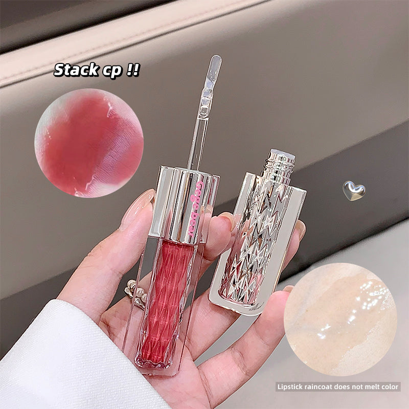 Lipstick with transparent casing held in a hand, showing color swatches.