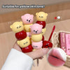 Colorful lip balm sticks with cartoon characters held by a hand, suitable for yellow skin tone.