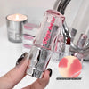 Lip balm with 'beige bear' branding held by a hand, with a blurred background of lip products.