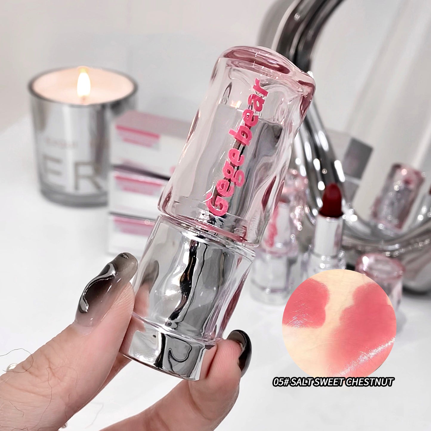 Lip balm with 'beige bear' branding held by a hand, with a blurred background of lip products.