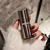 Hand holding a Gege bear lipstick with a blurred background