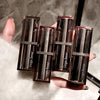 Four Gege bear lipsticks held in a hand against a neutral background
