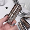 Hand holding a metallic lipstick with 'gege bear' branding, blurred background