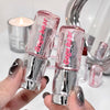 Two Gige bear lip glosses held by a hand with a blurred background