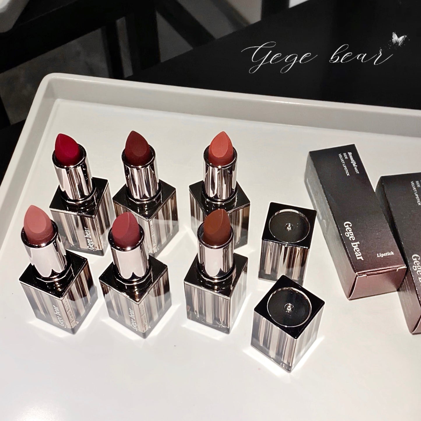 Set of lipsticks with visible brand 'Gege bear' on a white surface.