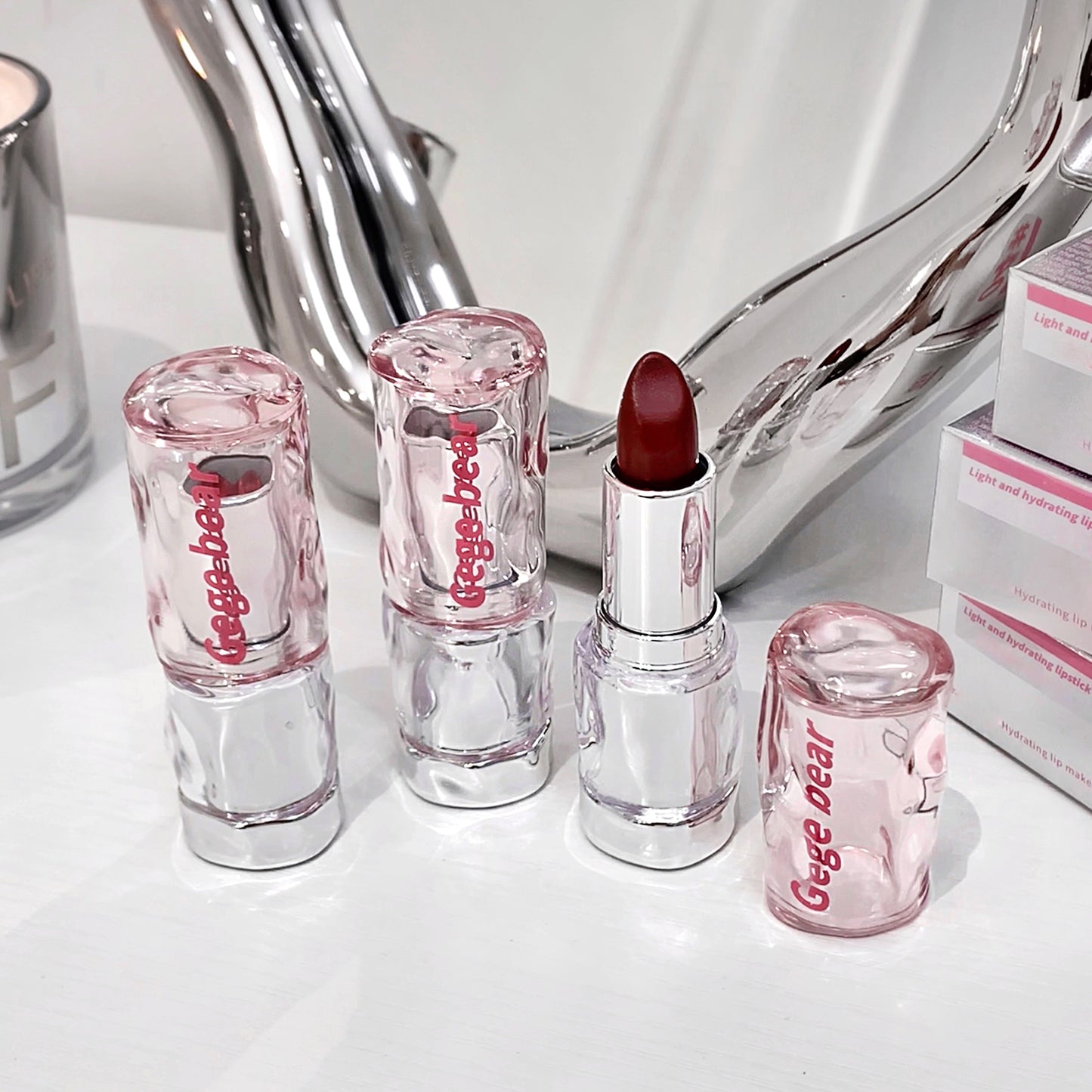 Set of Gege Bear lipsticks on a white surface with a mirror in the background