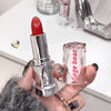 Red lipstick held by a hand with 'Gegebear' branding visible