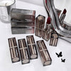Collection of Gege bear lipsticks and packaging on a white surface with a mirror and candle in the background.