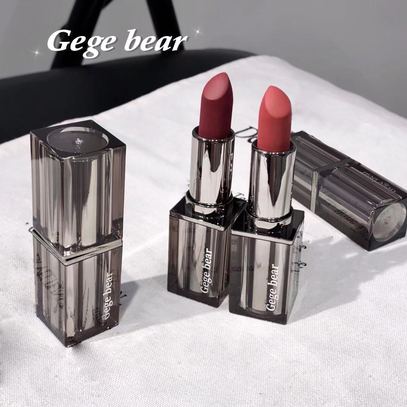 Two lipsticks with clear casings on a white surface, branded 'Gege bear'.