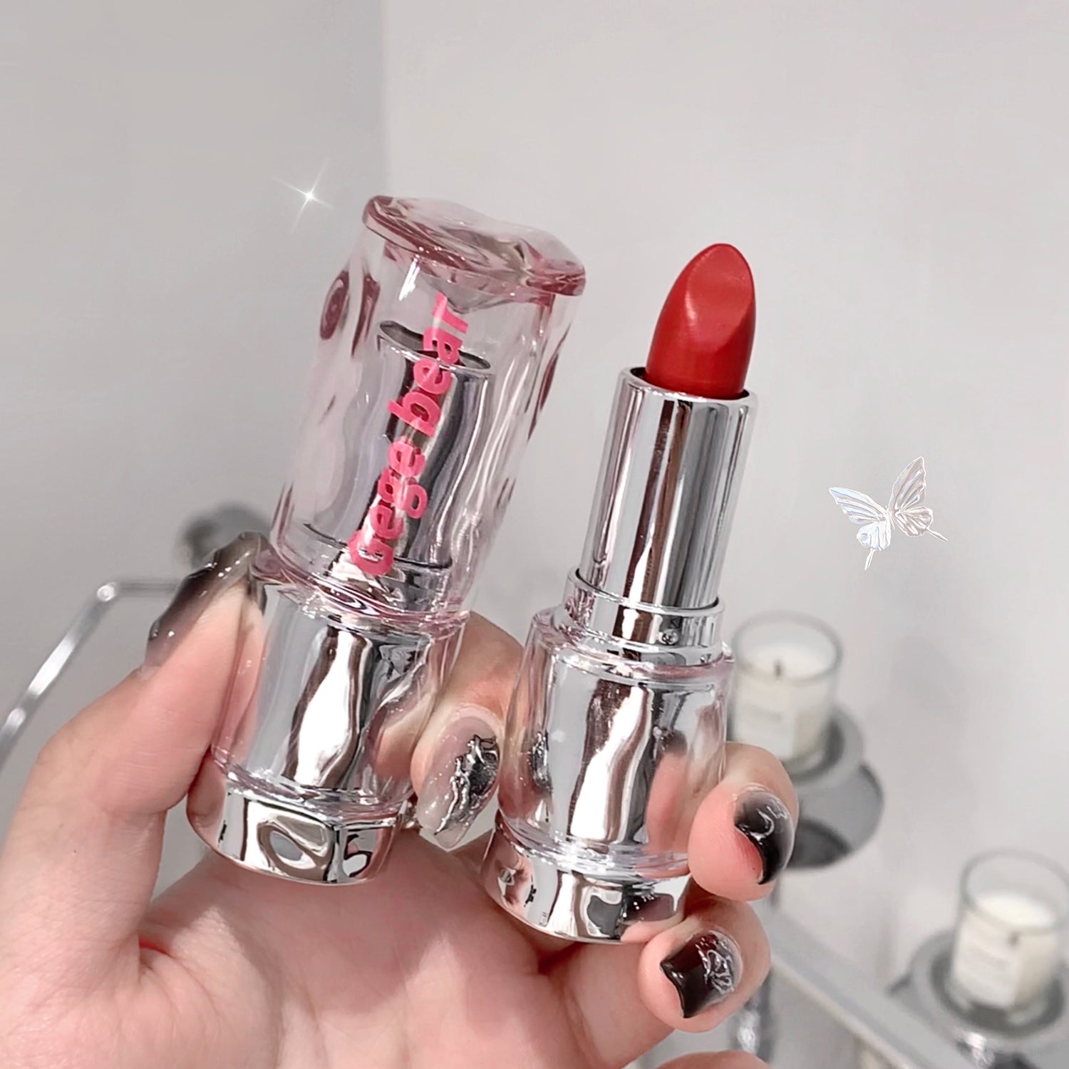 Two lipsticks held in a hand with a blurred background