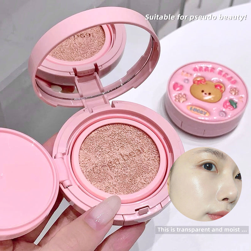 Pink cosmetic compact with a mirror, held by a hand, on a white background.