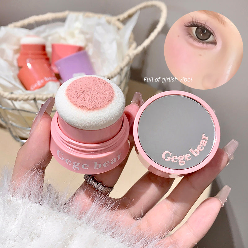 Pink makeup sponge and compact with 'Gege bear' branding, held by a hand.