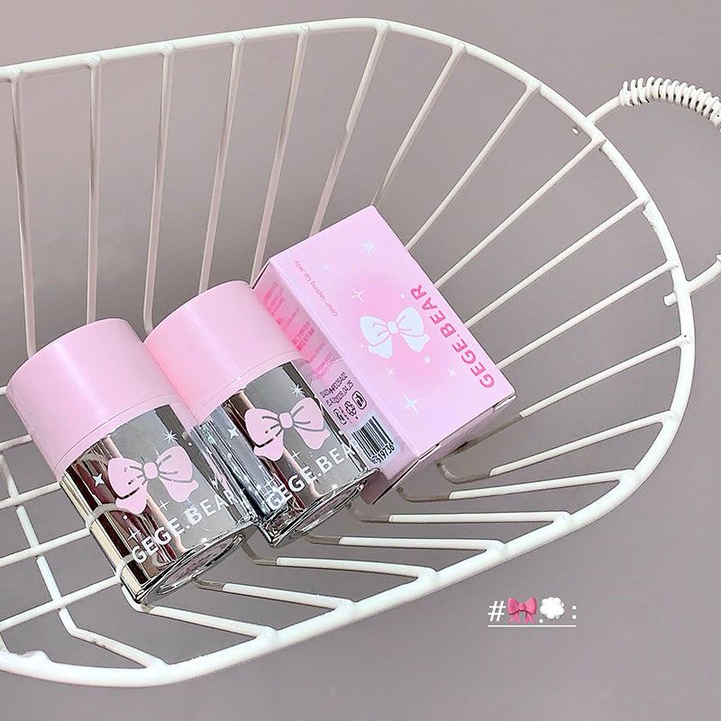 Two pink bottles and a box labeled 'Gee Bear' on a white metal shelf.