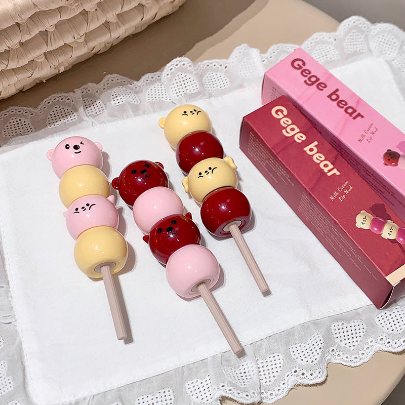 Colorful candy skewers with 'Gege bear' packaging on a lace surface