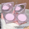 Four pink makeup balms in clear cases held by a person, with a blurred background.