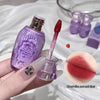 Purple lip gloss bottle with applicator held by a hand, close-up of lips with gloss applied.