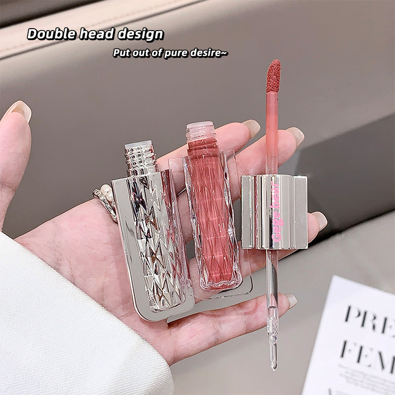 Lip gloss with double head design held in a hand against a neutral background