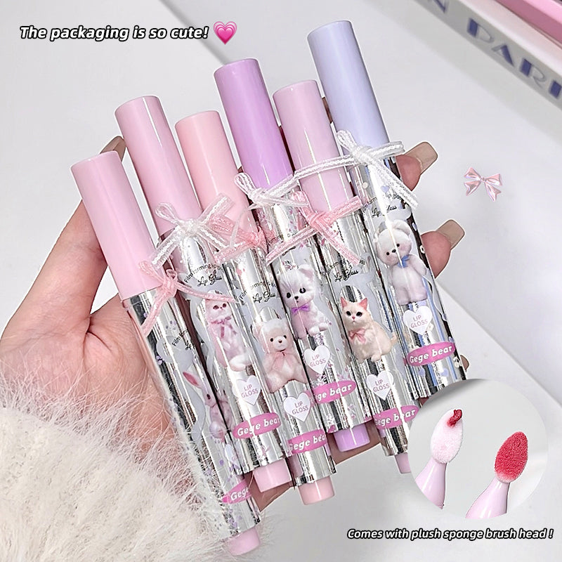Set of pink and purple makeup brushes with cute packaging held by a hand.
