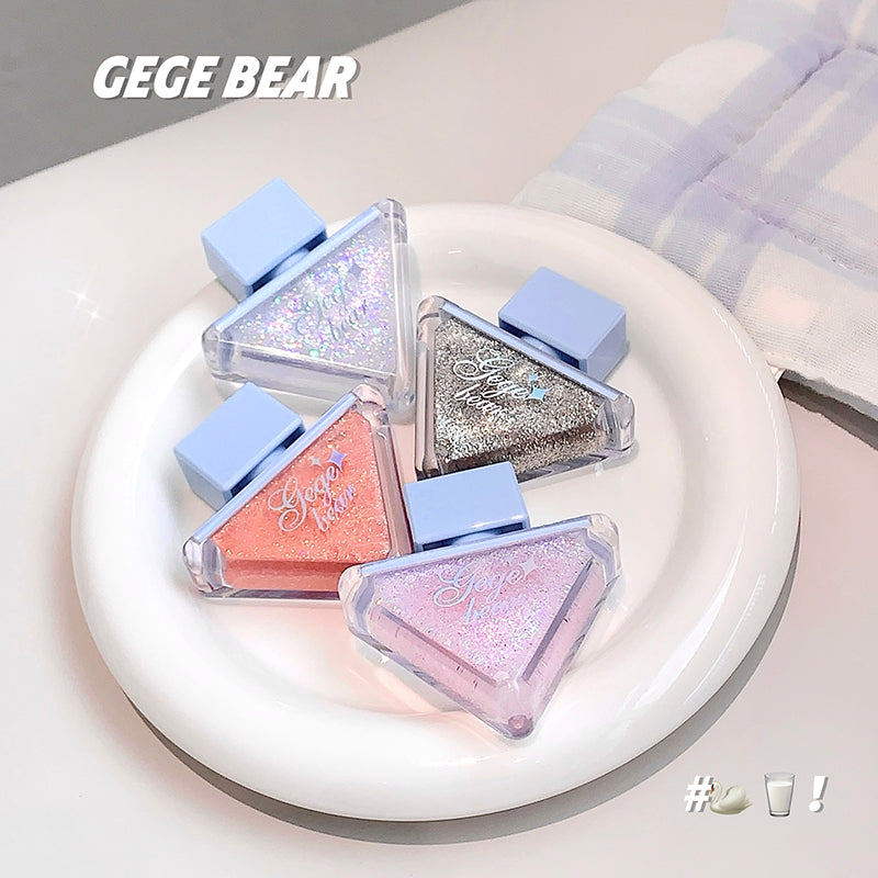 Triangular-shaped makeup products with glittery finish on a white plate, branded 'GEGE BEAR'.