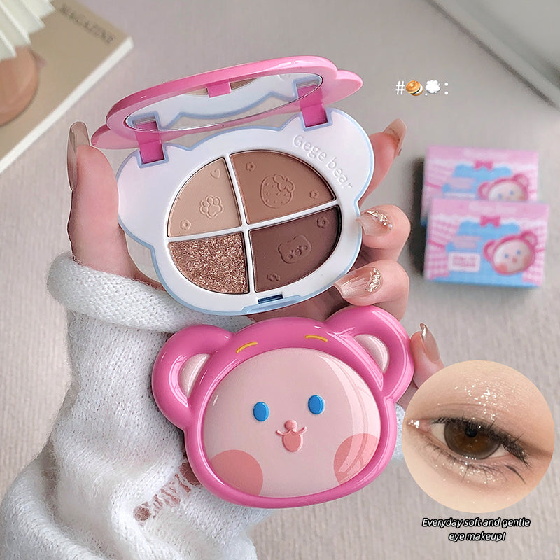 Makeup palette with cartoon design held by a hand, close-up of eye makeup application.