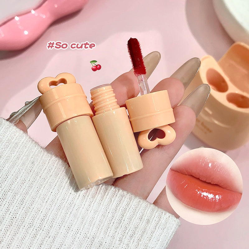 Lip gloss set with applicator and close-up of lips wearing the product on a pink background.