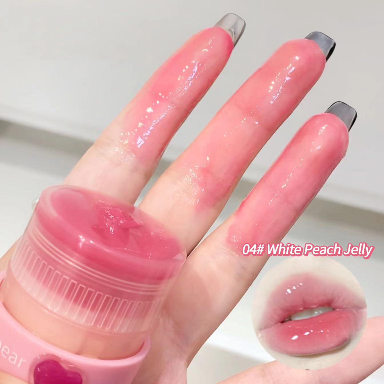 Hand with pink nail polish holding a lip balm labeled 'White Peach Jelly', with a close-up of lips wearing the same shade.