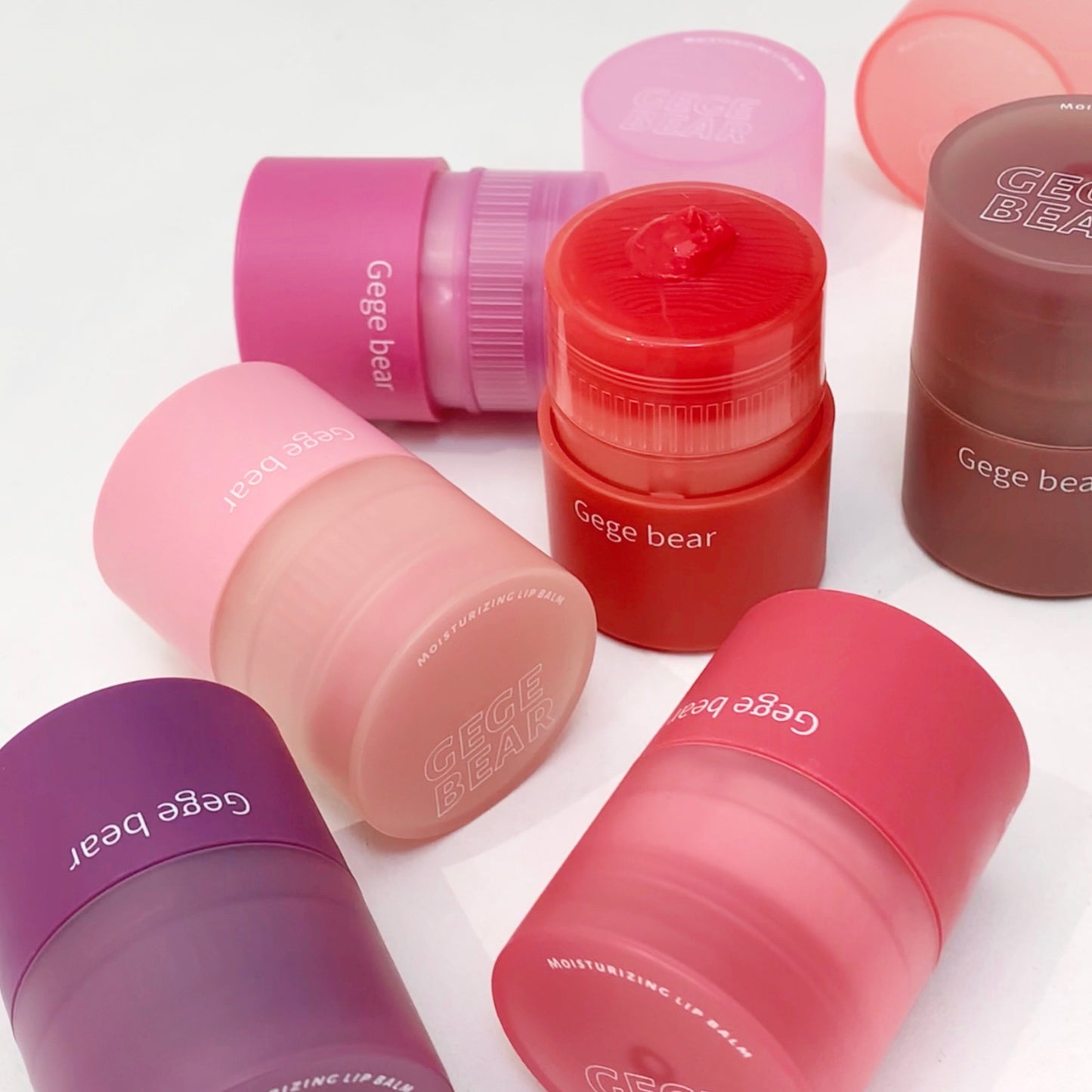 Set of colorful lip balm containers with 'Gege bear' branding on a white background