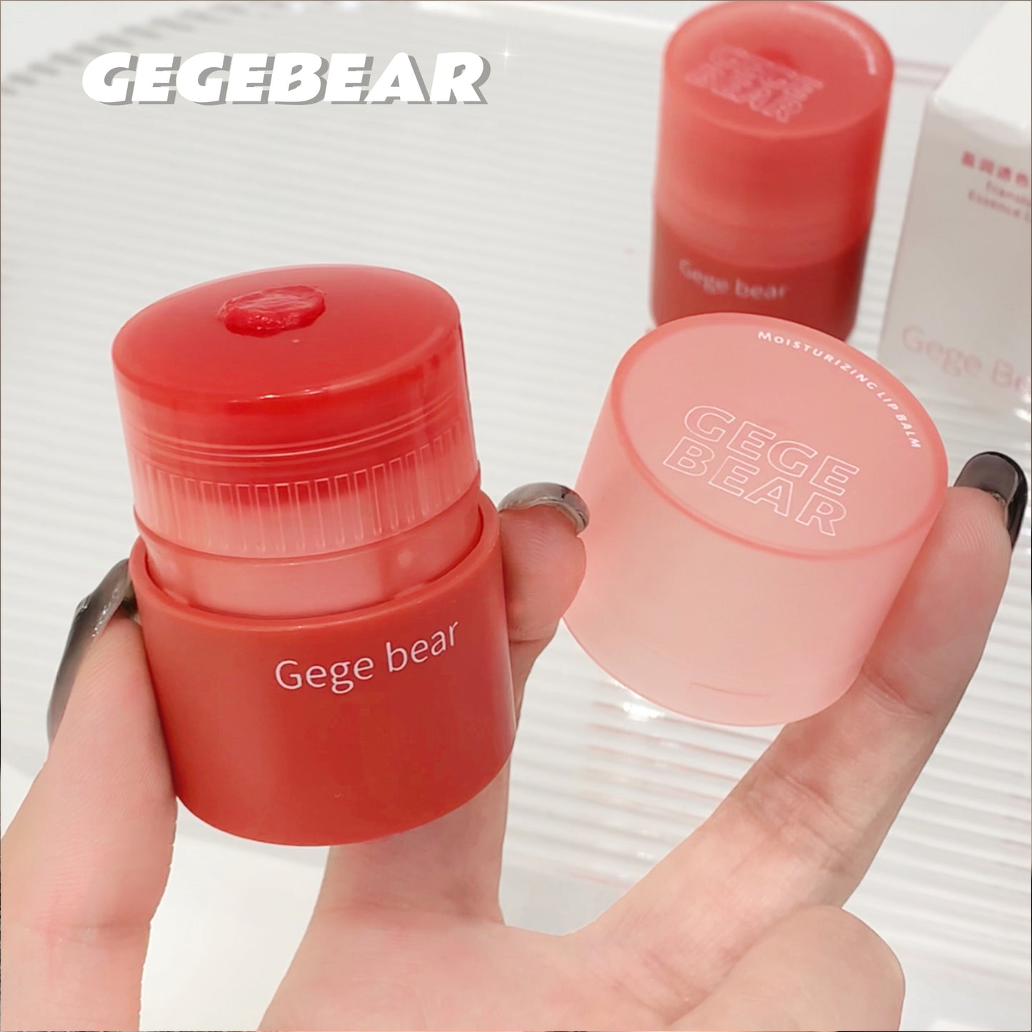 Two small red containers with 'Gege bear' branding held by a hand against a light background.