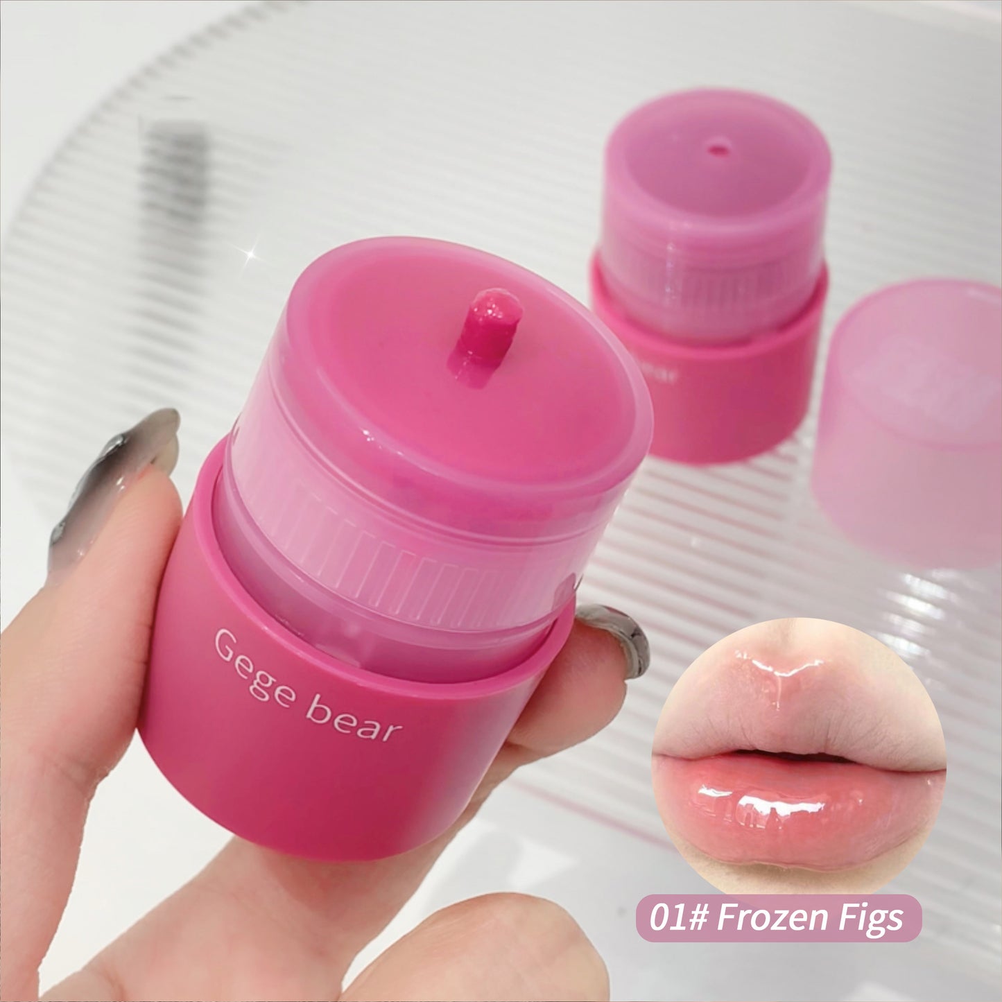 Pink lip balm container with 'Gege bear' branding, held by a hand, with a close-up of lips wearing the product and 'Frozen Figs' color swatch.