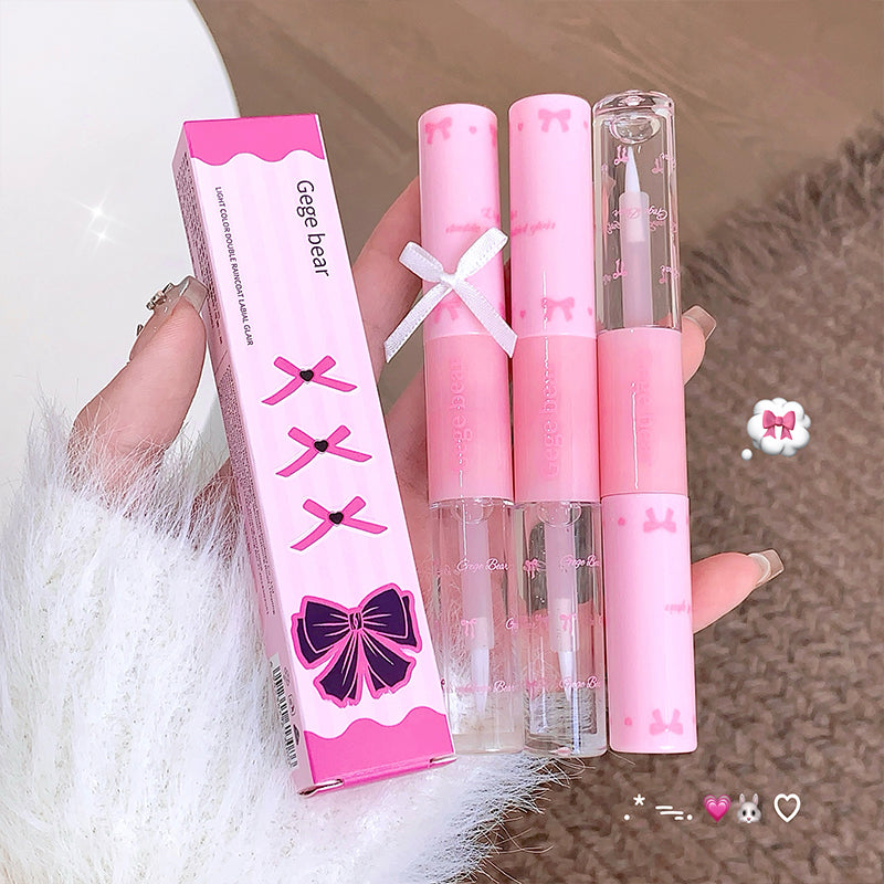 Set of pink lip products with packaging held by a hand on a textured surface.