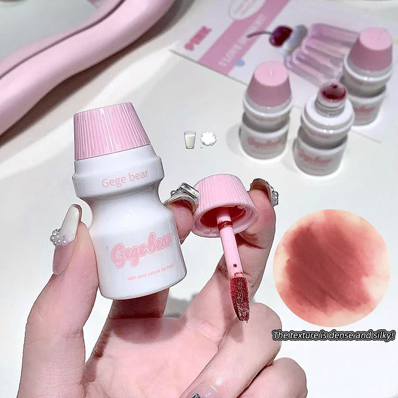 Small cosmetic bottle with pink cap and brush, held by a hand, with a close-up of the product color on a white background.