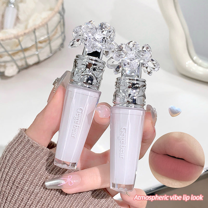 Two lip glosses with decorative caps held by a hand, with a close-up of lips and text 'Atmospheric vibe lip look' in the corner.