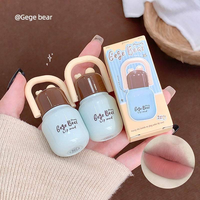 Two lip balms and their packaging held by a hand, with a close-up of lips in the corner.