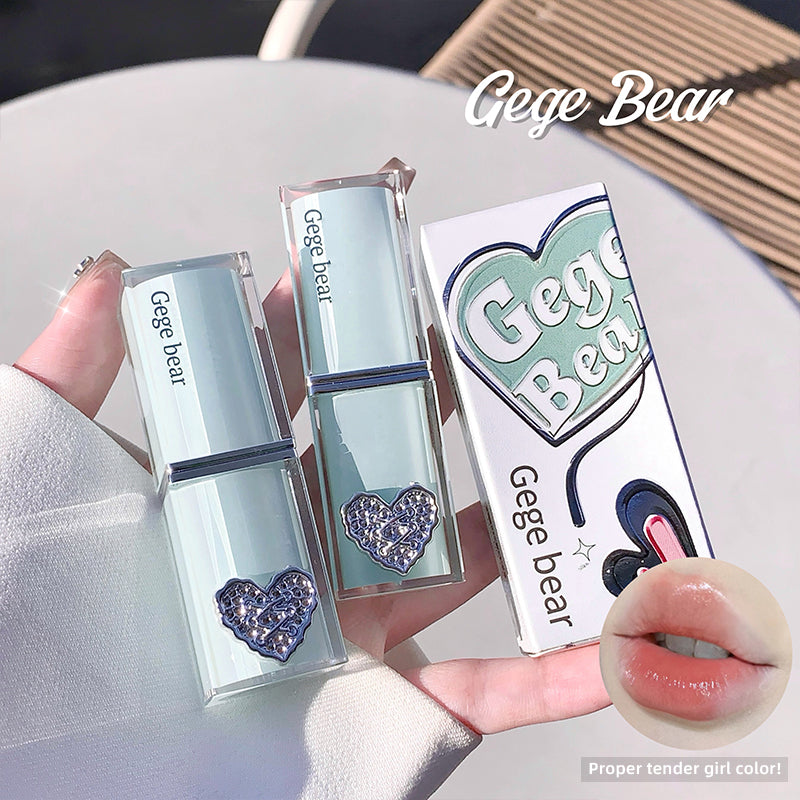 Lip gloss with heart design and 'Gege Bear' branding, held by a hand.