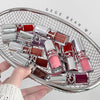 Collection of lip glosses on a decorative tray with 'GEGE BEAR' branding.
