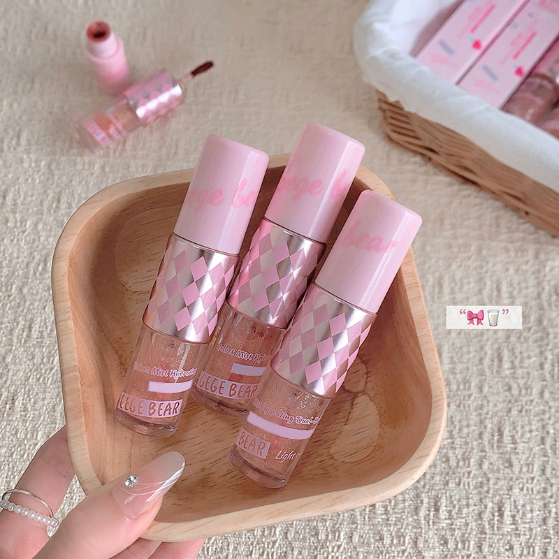 Three pink and clear cosmetic bottles with checkered pattern on a wooden tray.
