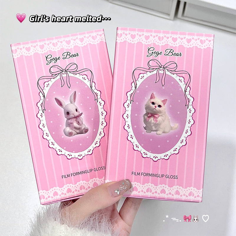 Two pink 'Gege Bear' lip gloss packages held by a hand on a white background.