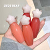Four small bottles with star-shaped caps held in a hand, branded 'GEGE BEAR'.