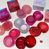 Collection of colorful lip balm containers with 'gege bear' branding on a white background.