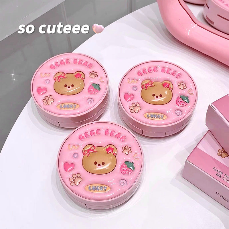 Three pink compact mirrors with bear design on a white surface.