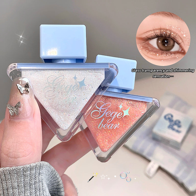 Triangular makeup product with 'Geege bear' branding, held by a hand, with close-up of eye wearing glitter.