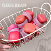Pink and red containers with 'GEGE BEAR' branding in a white basket.