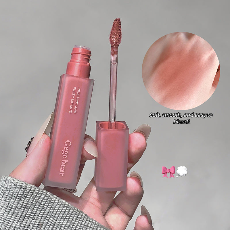 Lip gloss with applicator and close-up of color on a gray background
