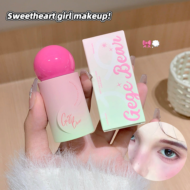 Hand holding a pink makeup product with 'Gige Bear' branding, close-up of eye with makeup application.