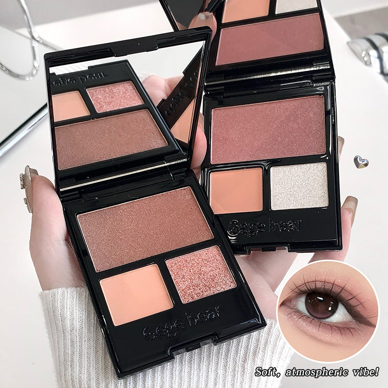 Makeup palettes with eyeshadows and a compact mirror, held by a hand.